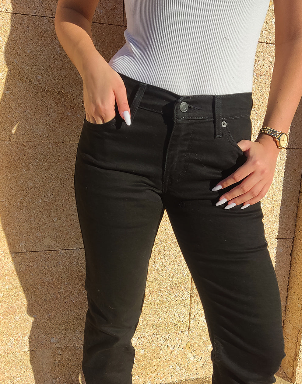 Women wearing Black 511 Levis Jeans against a a wall