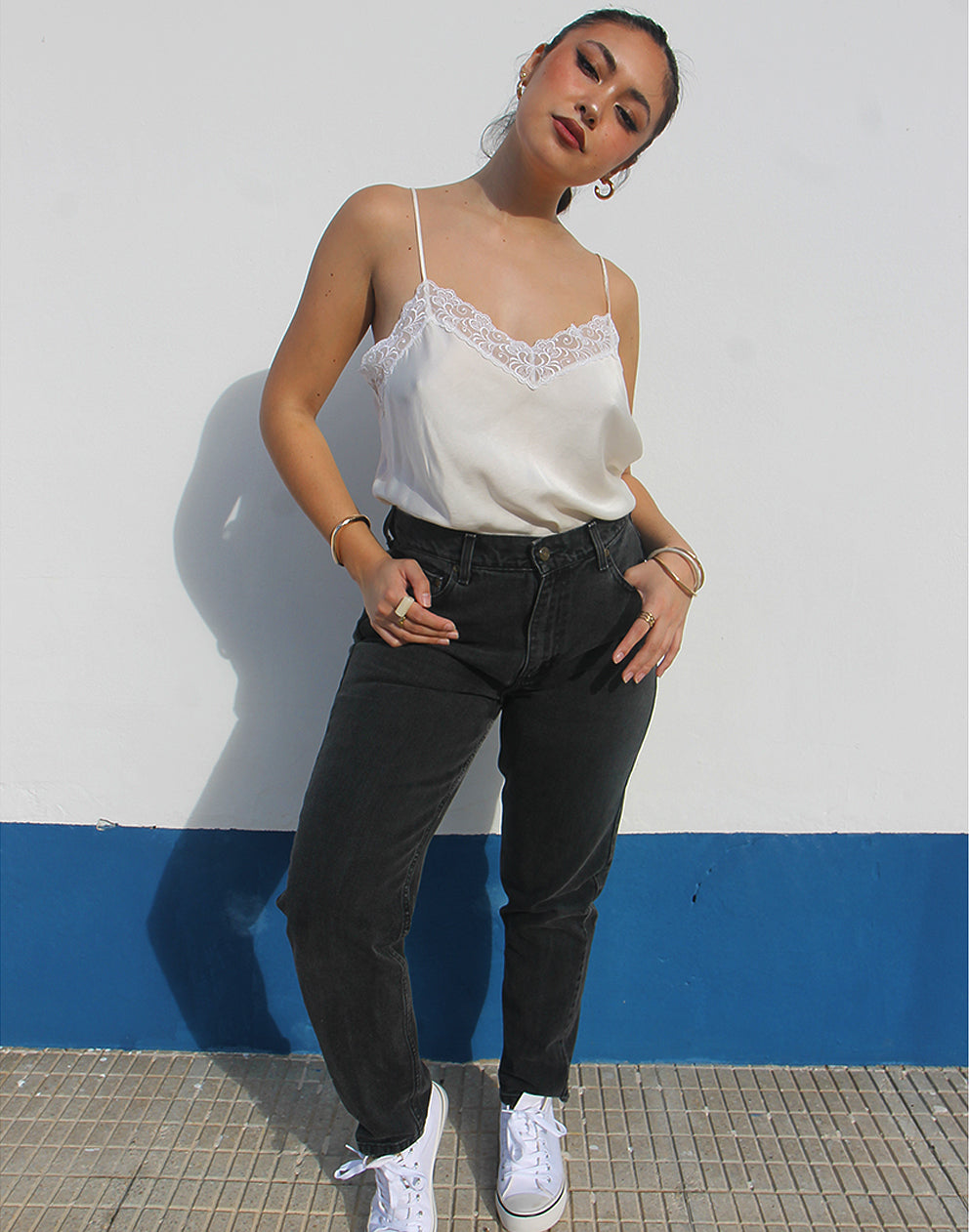 Woman wearing vintage Liz Clairborne jeans against a white wall