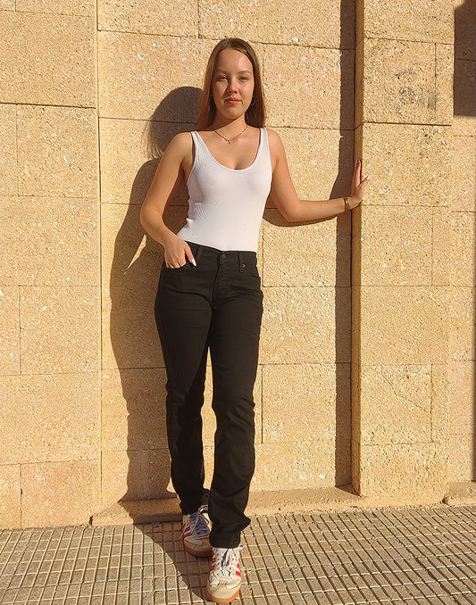 Women wearing Black 511 Levis Jeans against a a wall 