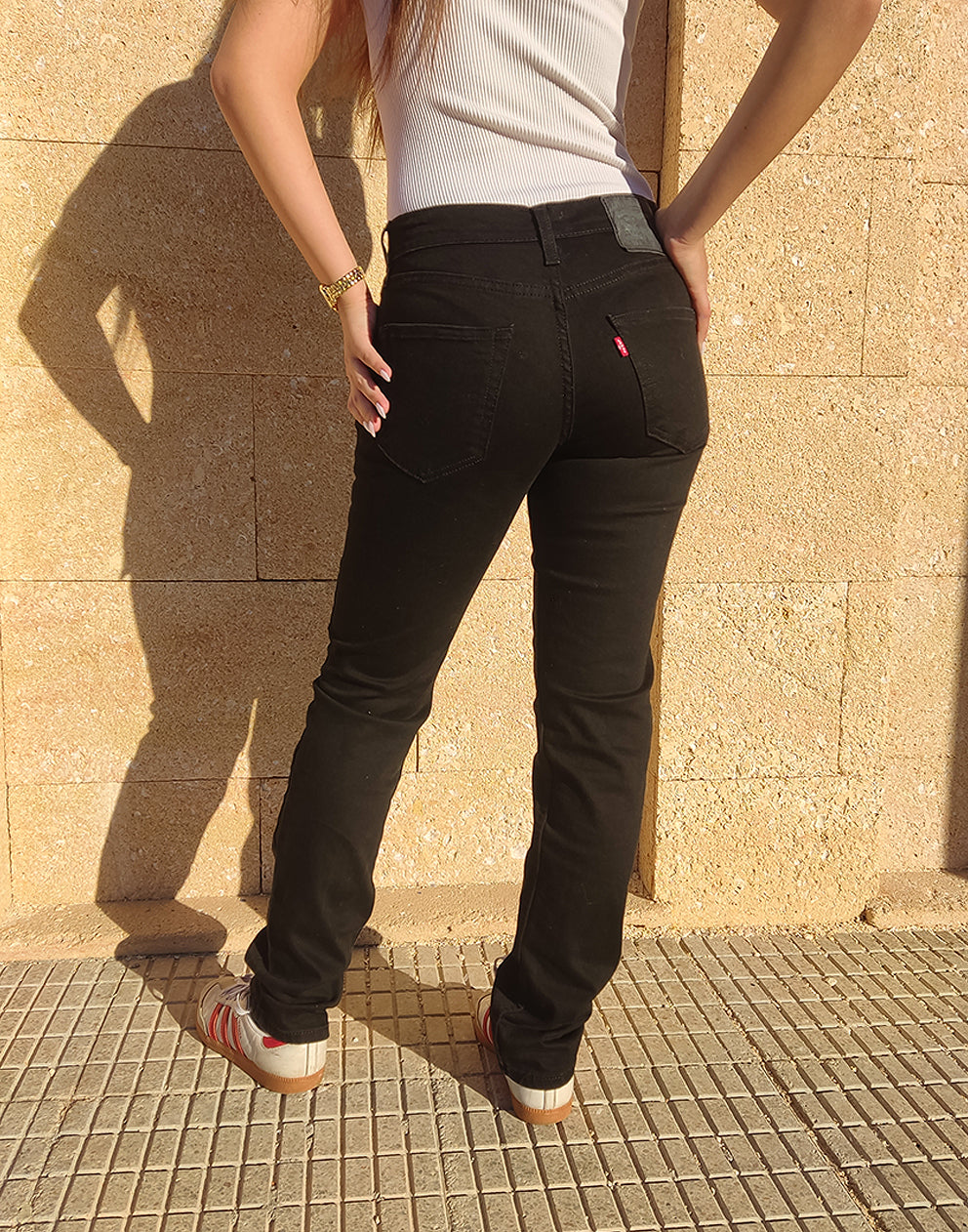 Women wearing Black 511 Levis Jeans against a a wall 