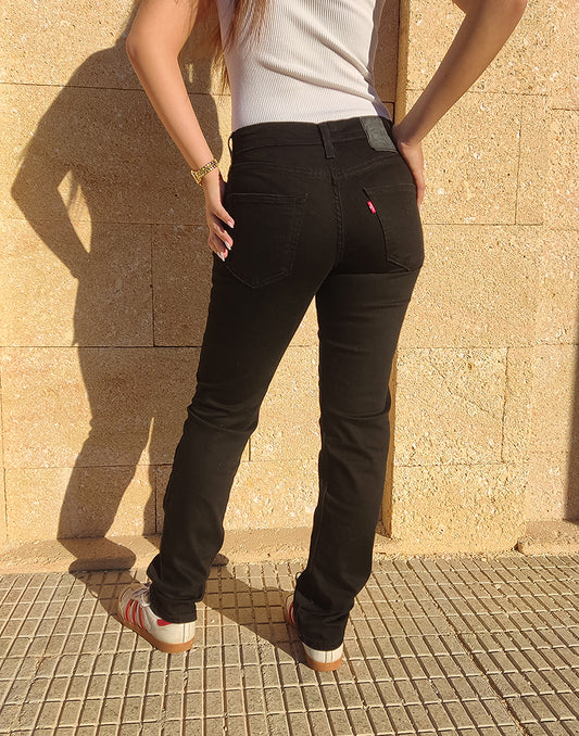 Women wearing Black 511 Levis Jeans against a a wall 