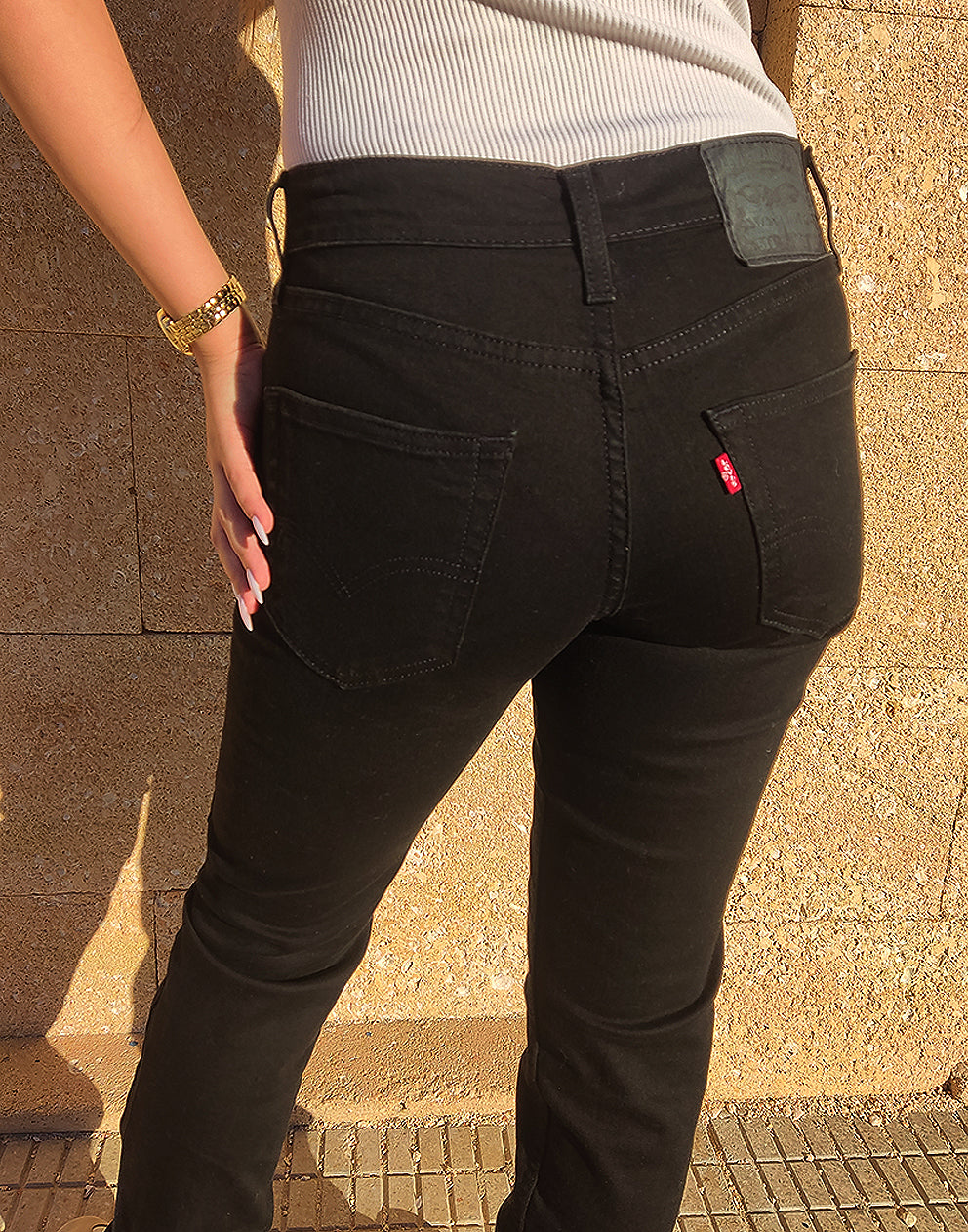 Women wearing Black 511 Levis Jeans against a a wall 