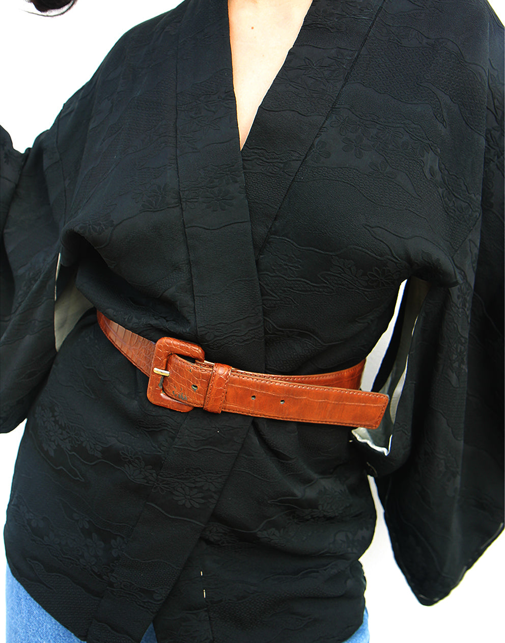 woman wearing black silk haori kimono jacket against a white wall