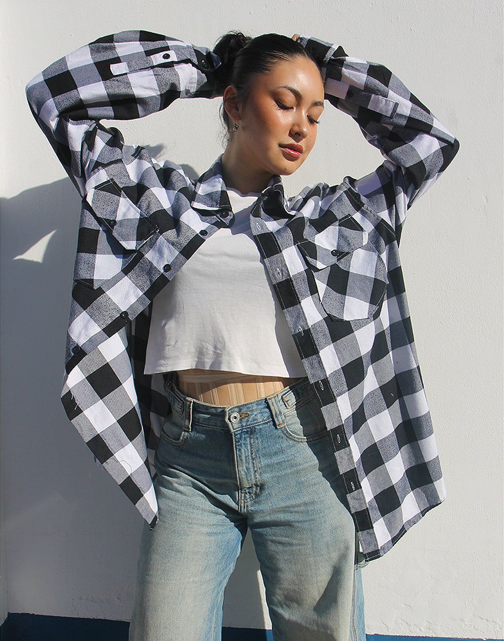 Front view of a black and white checked flannel shirt with double chest pockets and button fastenings.