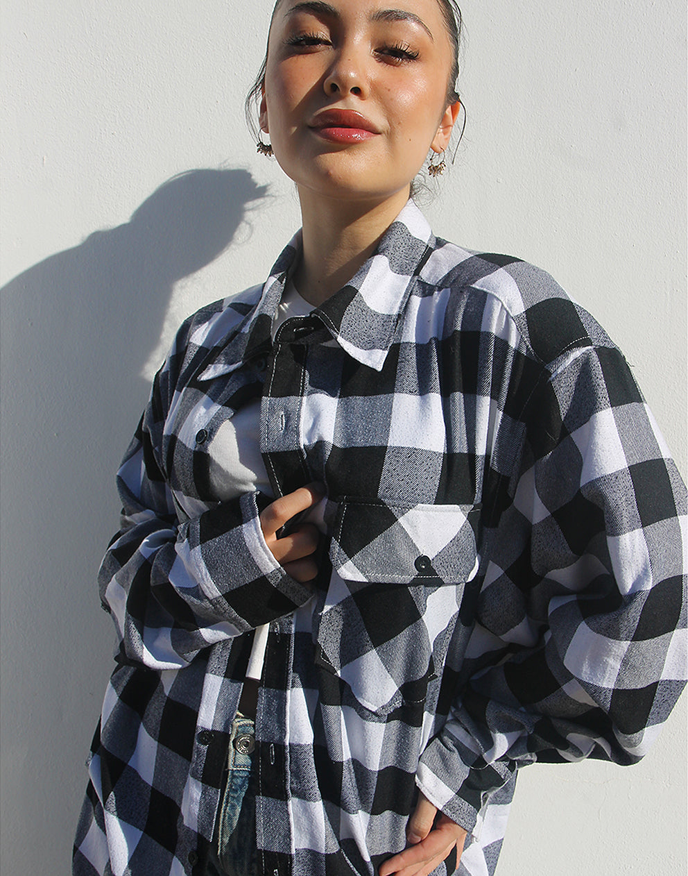 Front view of a black and white checked flannel shirt with double chest pockets and button fastenings.