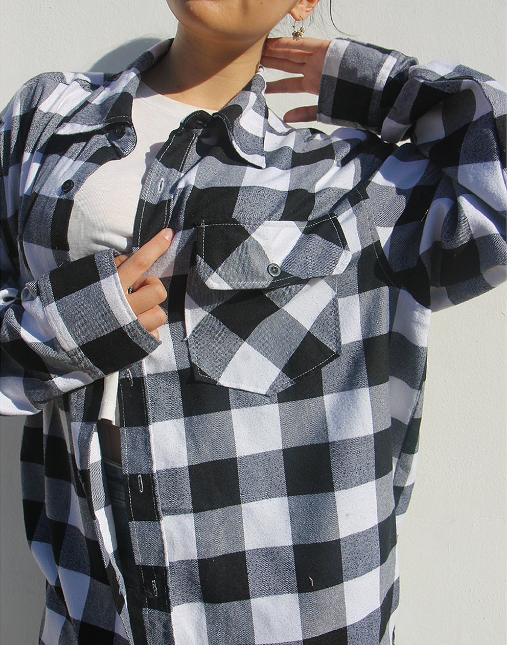 Close-up of the soft monochrome plaid fabric texture and buttons.