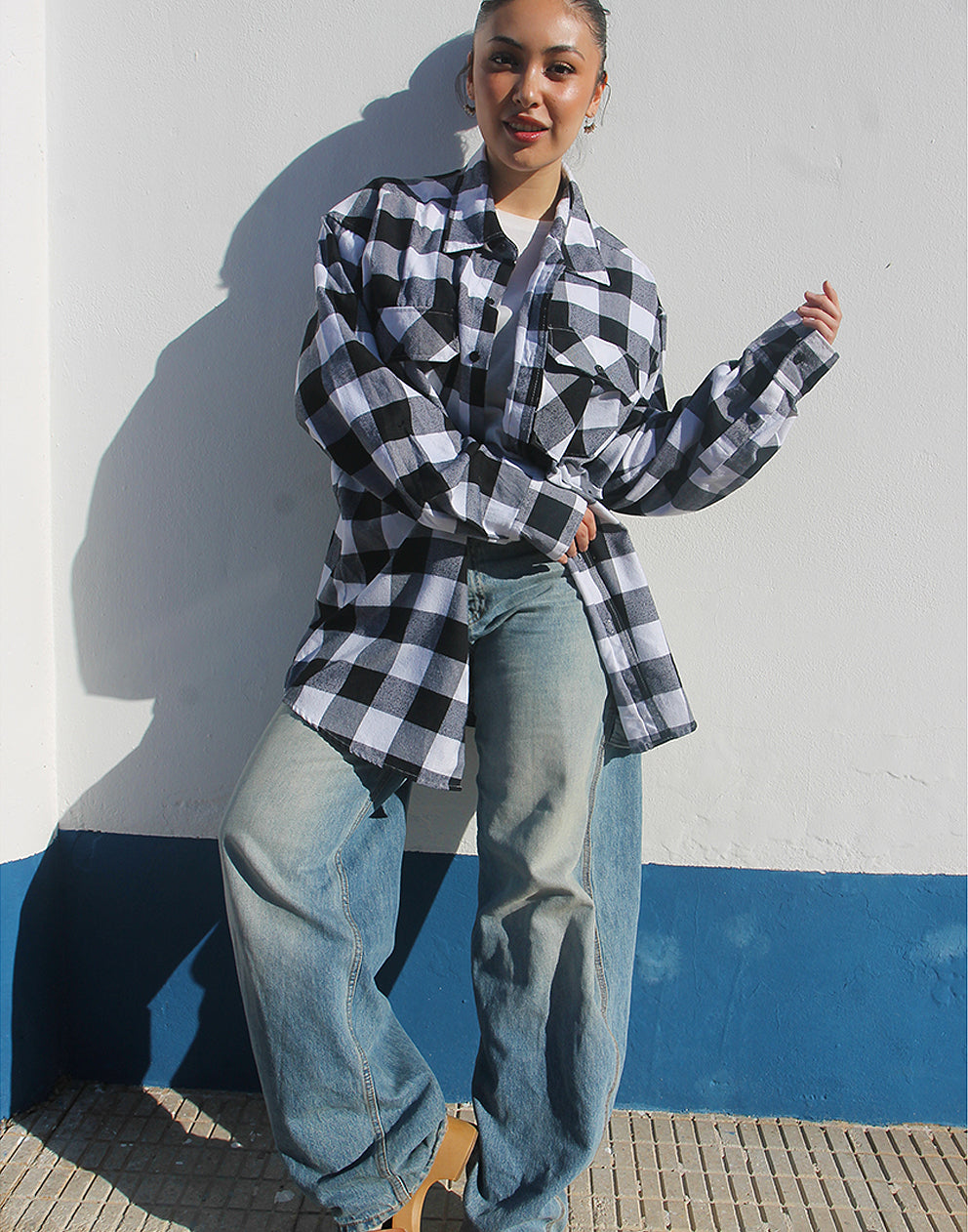 Front view of a black and white checked flannel shirt with double chest pockets and popper button fastenings.