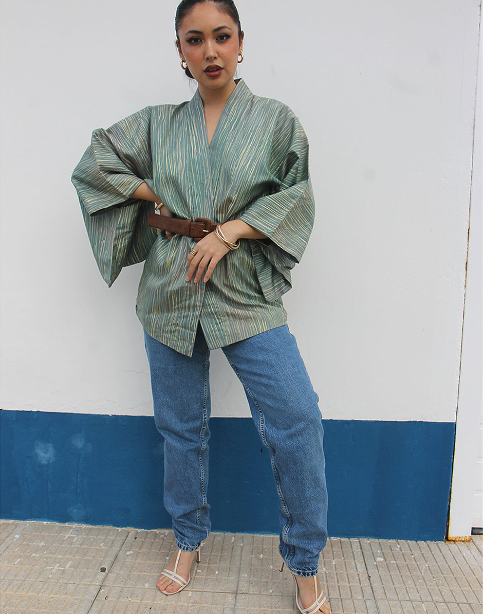 WOMAN WEARING GREEN HAORI KIMONO JACKET AGAINSTA A WHITE WALL