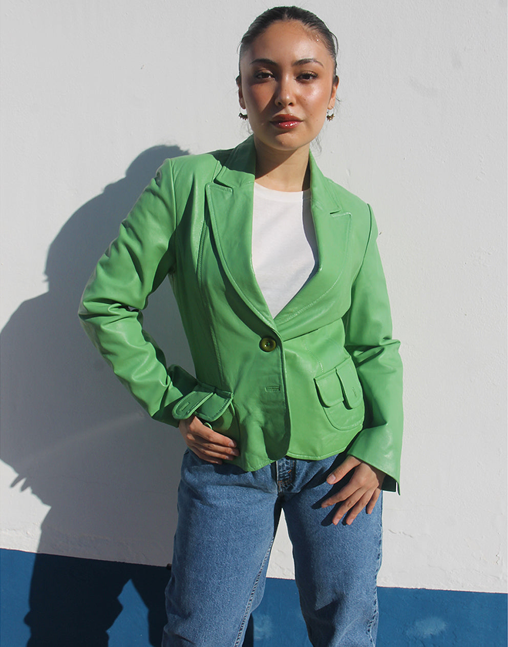 Front view of a green leather jacket featuring a V-neckline and a single-button closure.