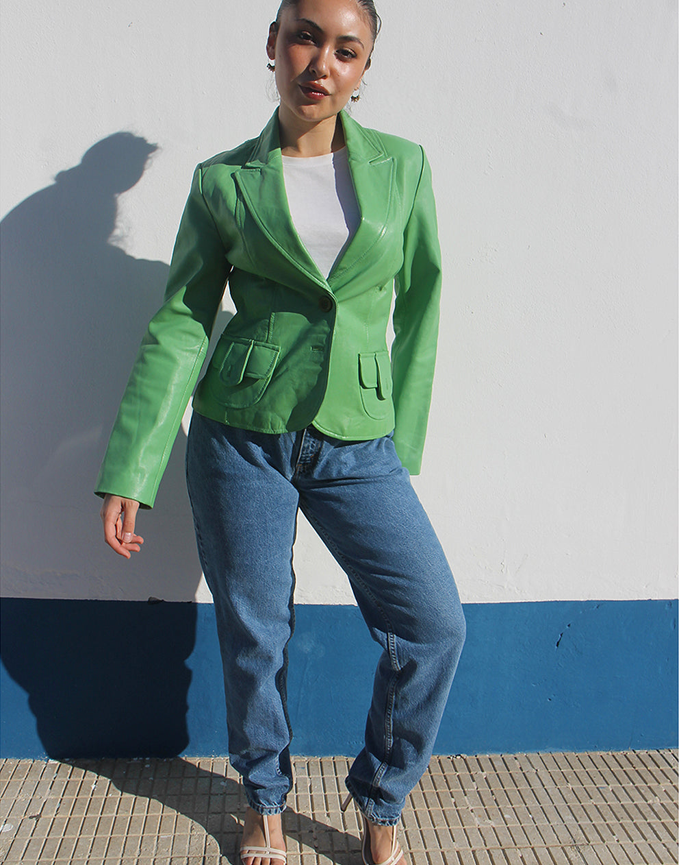 Front view of a green leather jacket featuring a V-neckline and a single-button closure.