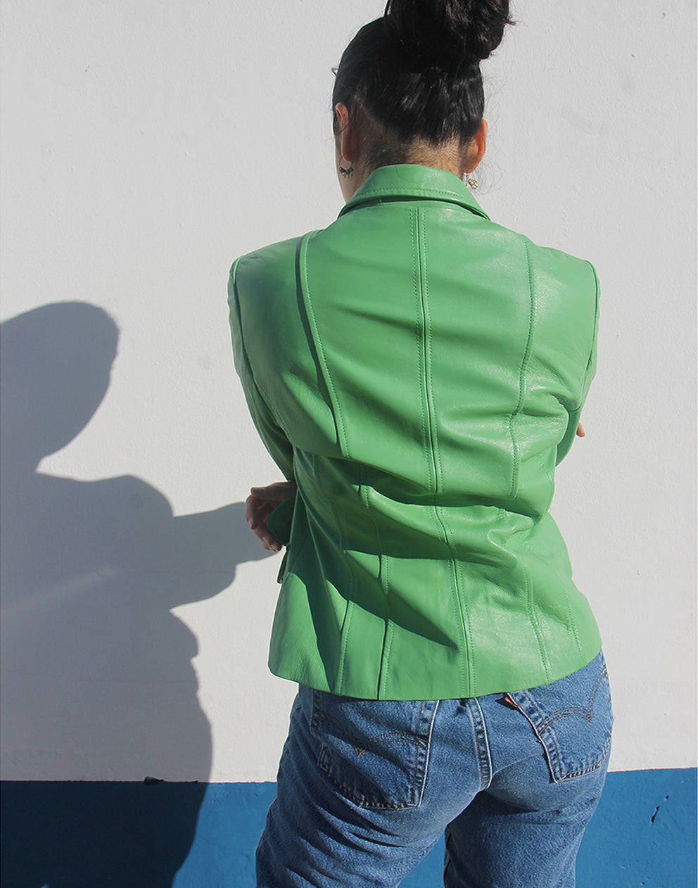 Rear view of the green leather blazer showing its tailored fit and clean silhouette.