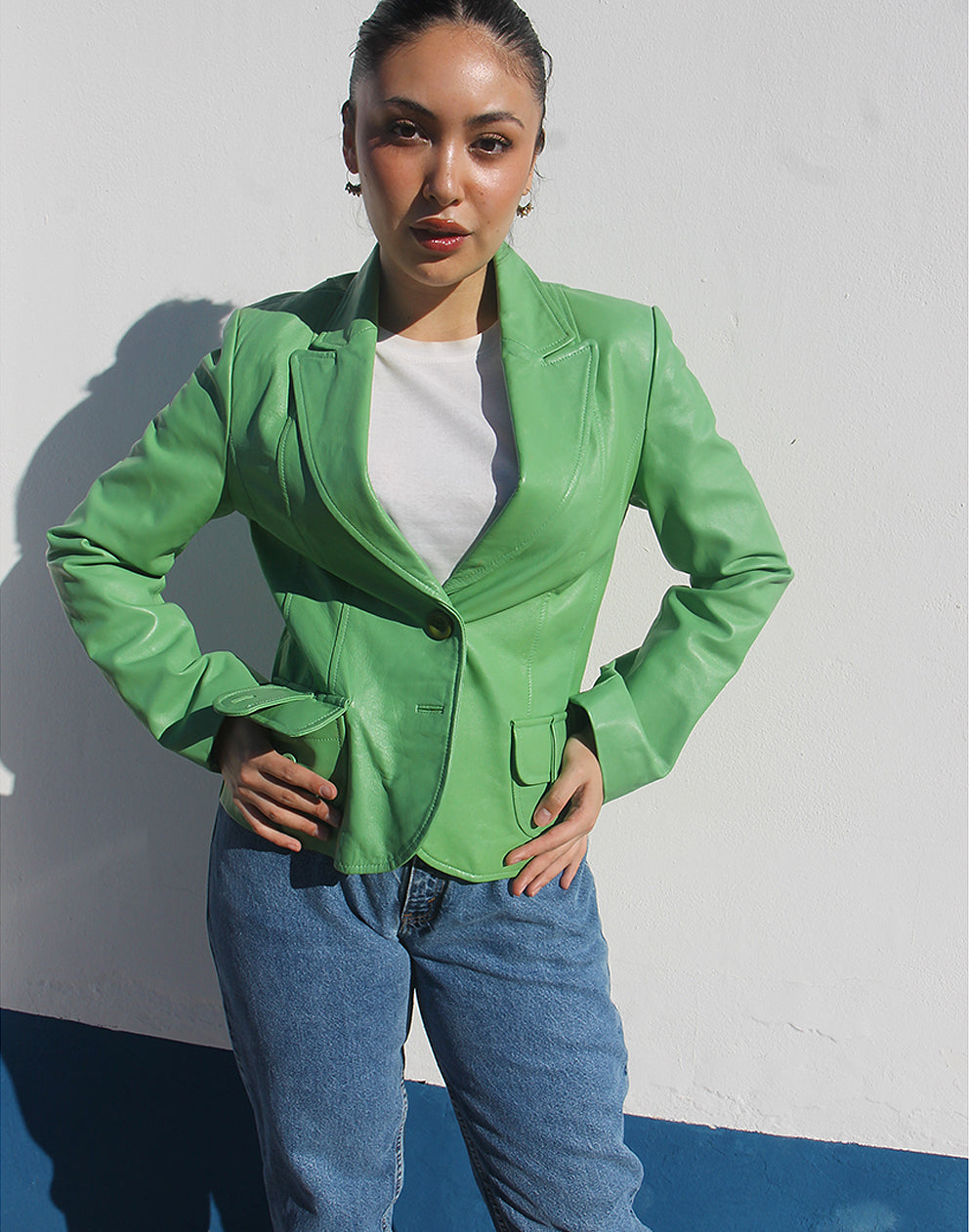 Front view of a green leather jacket featuring a V-neckline and a single-button closure.