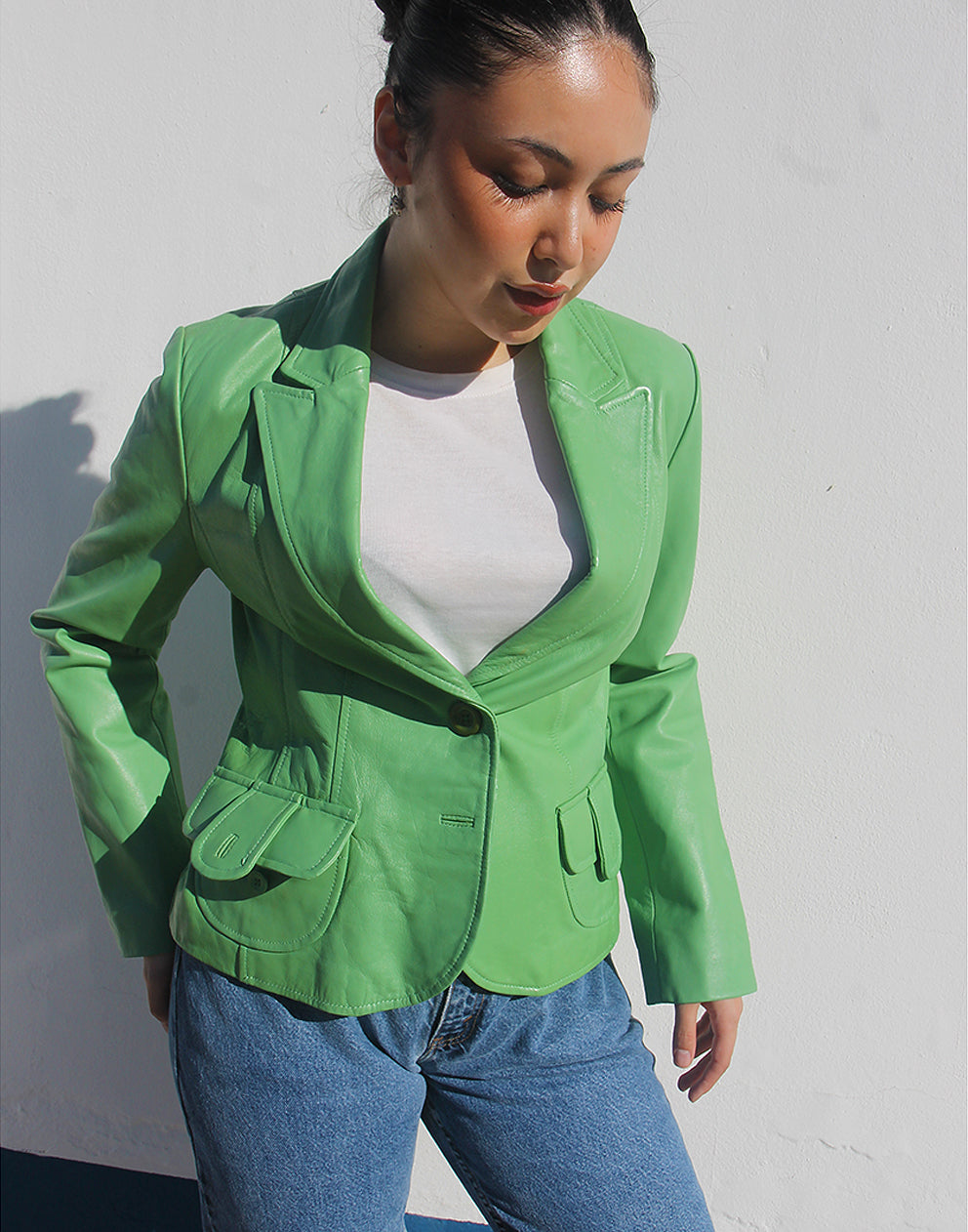 Front view of a green leather jacket featuring a V-neckline and a single-button closure.