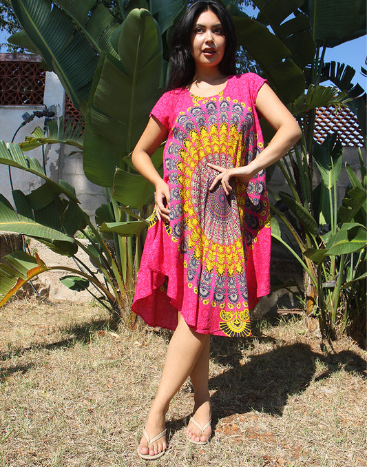 A woman wearing a bright pink beach dress with a large yellow print, standing outdoors