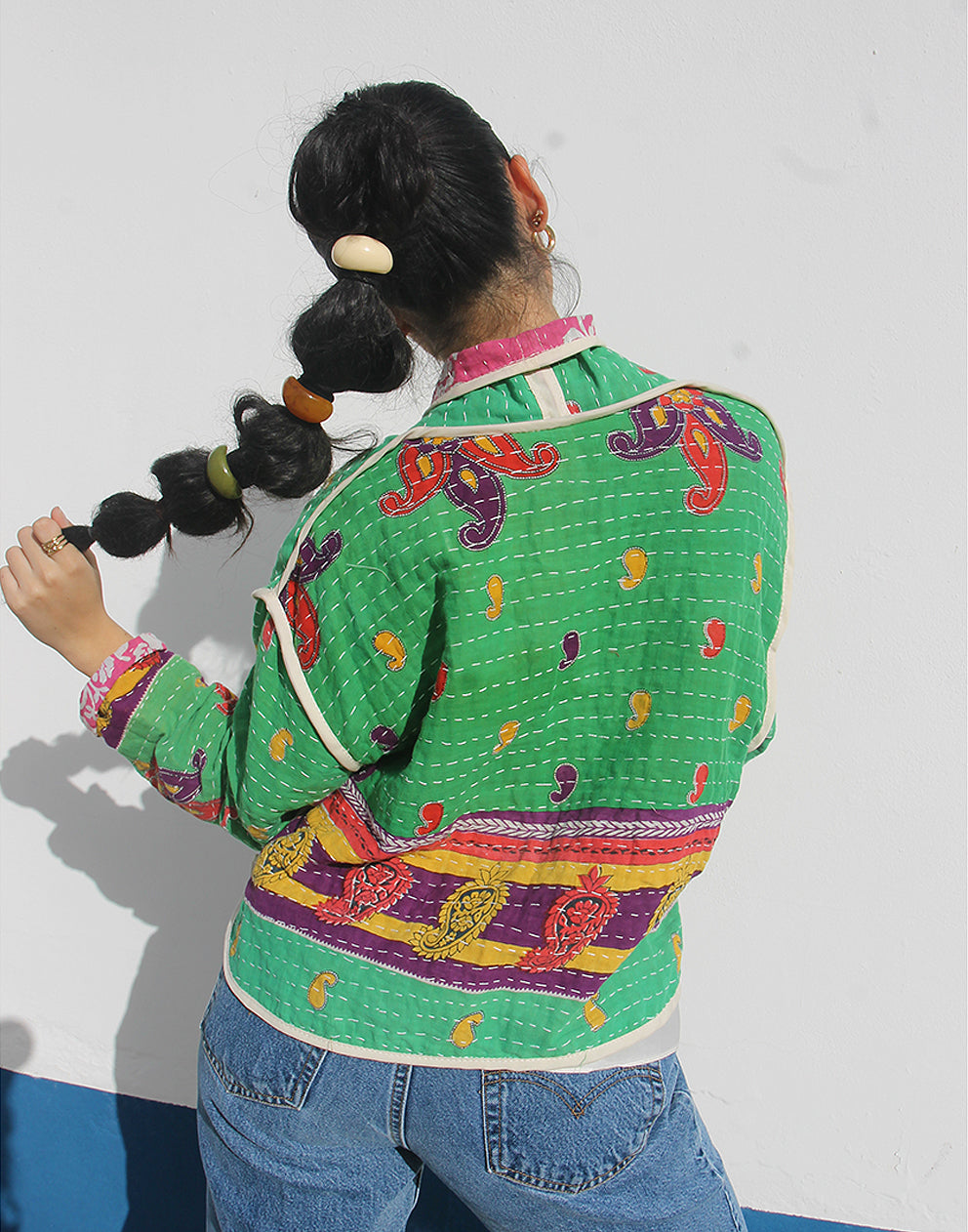 Person wearing a green cotton jacket with a white background
