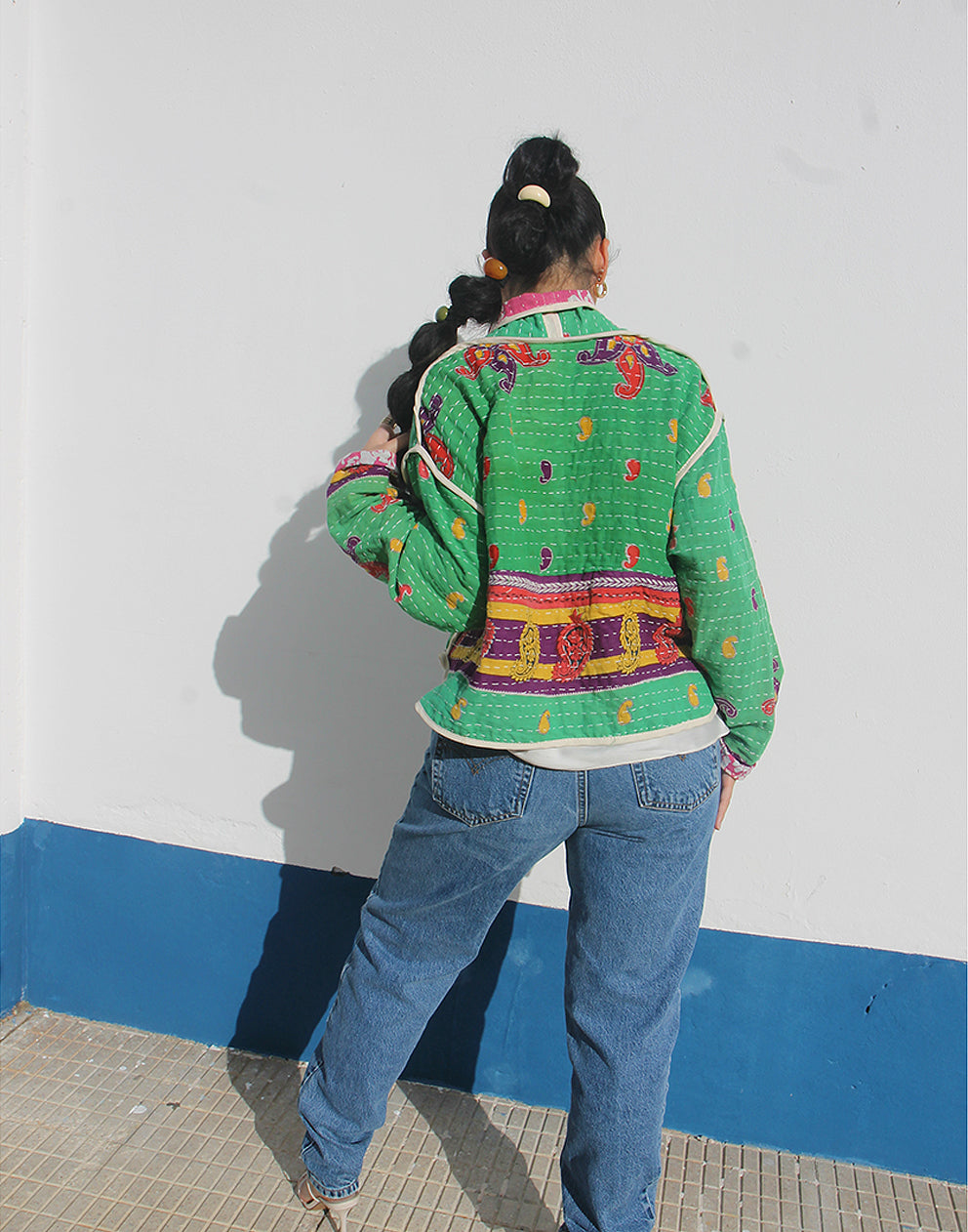 Person wearing a green cotton jacket with a white background