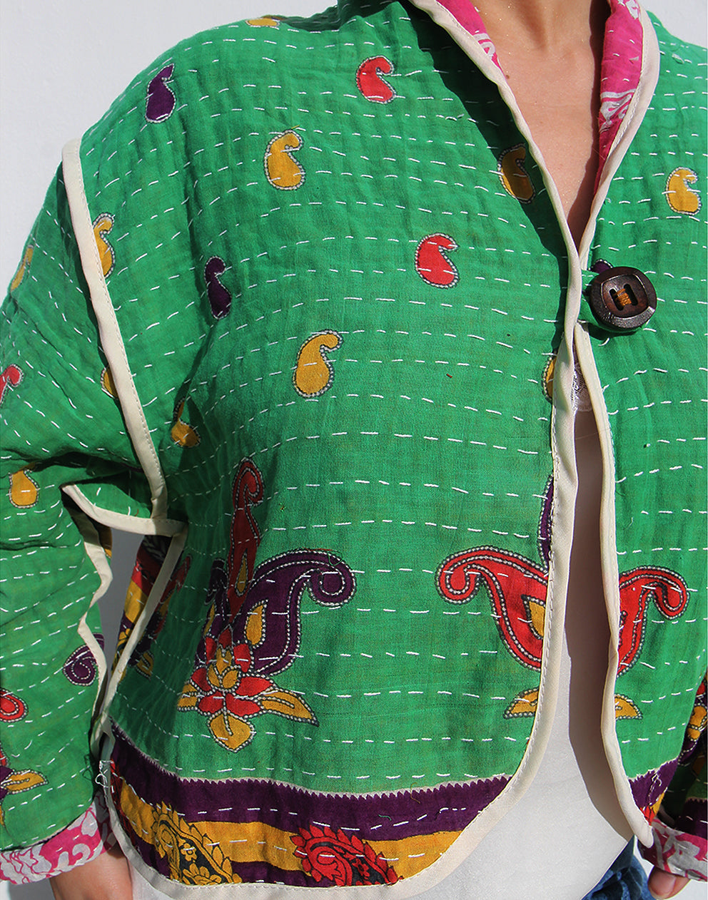 Person wearing a green cotton jacket with a white background