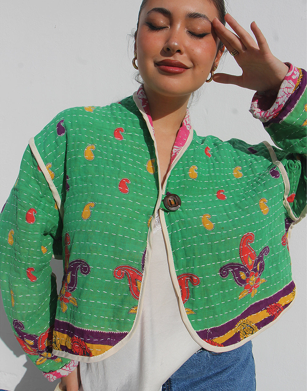 Person wearing a green cotton jacket with a white background