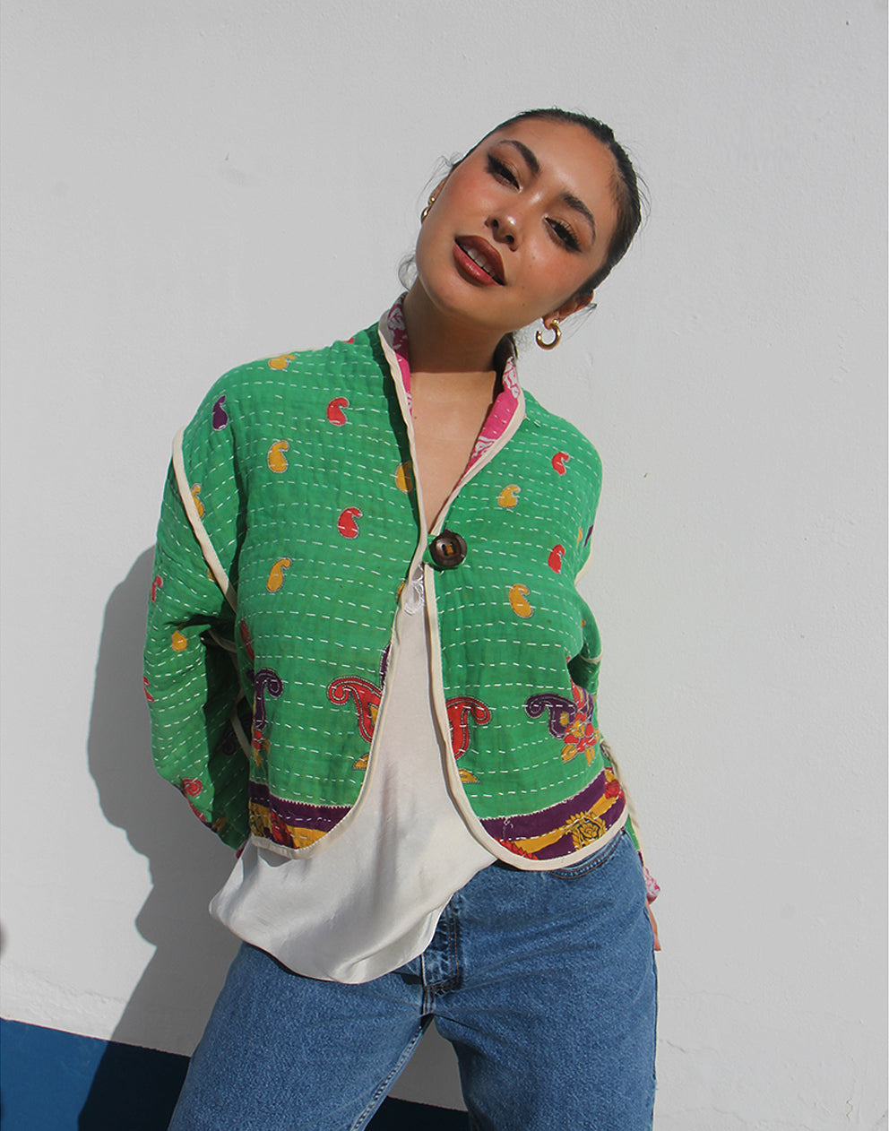 Person wearing a green cotton jacket with a white background