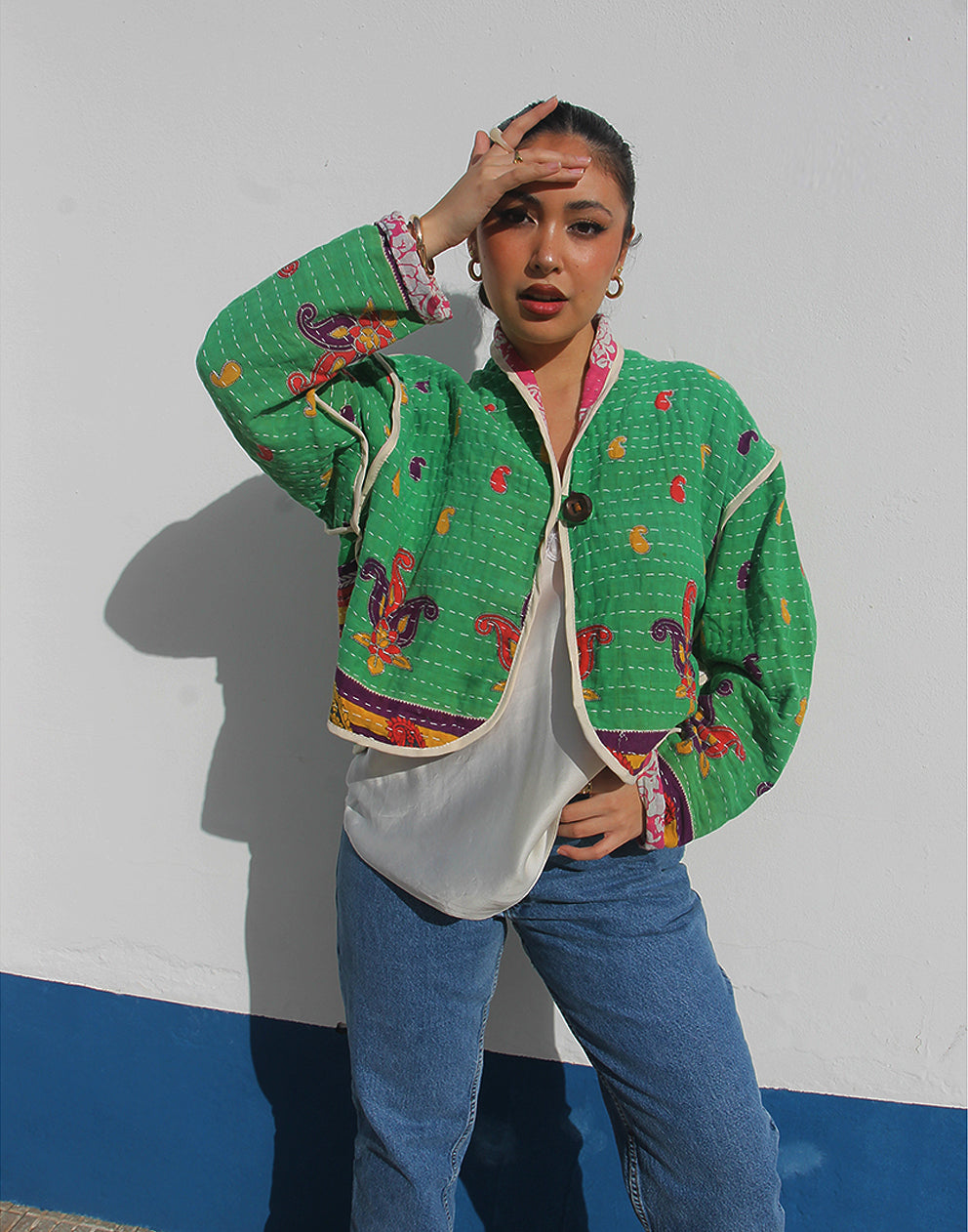 Person wearing a green cotton jacket with a white background