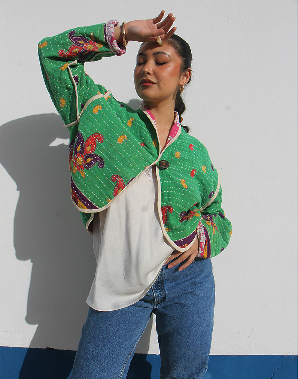 Person wearing a green cotton jacket with a white background