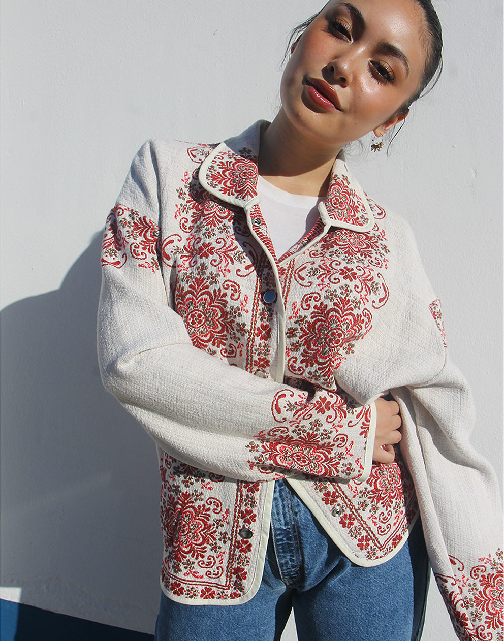 Front view of women’s cream and red floral tapestry coat with classic collar and snap buttons.