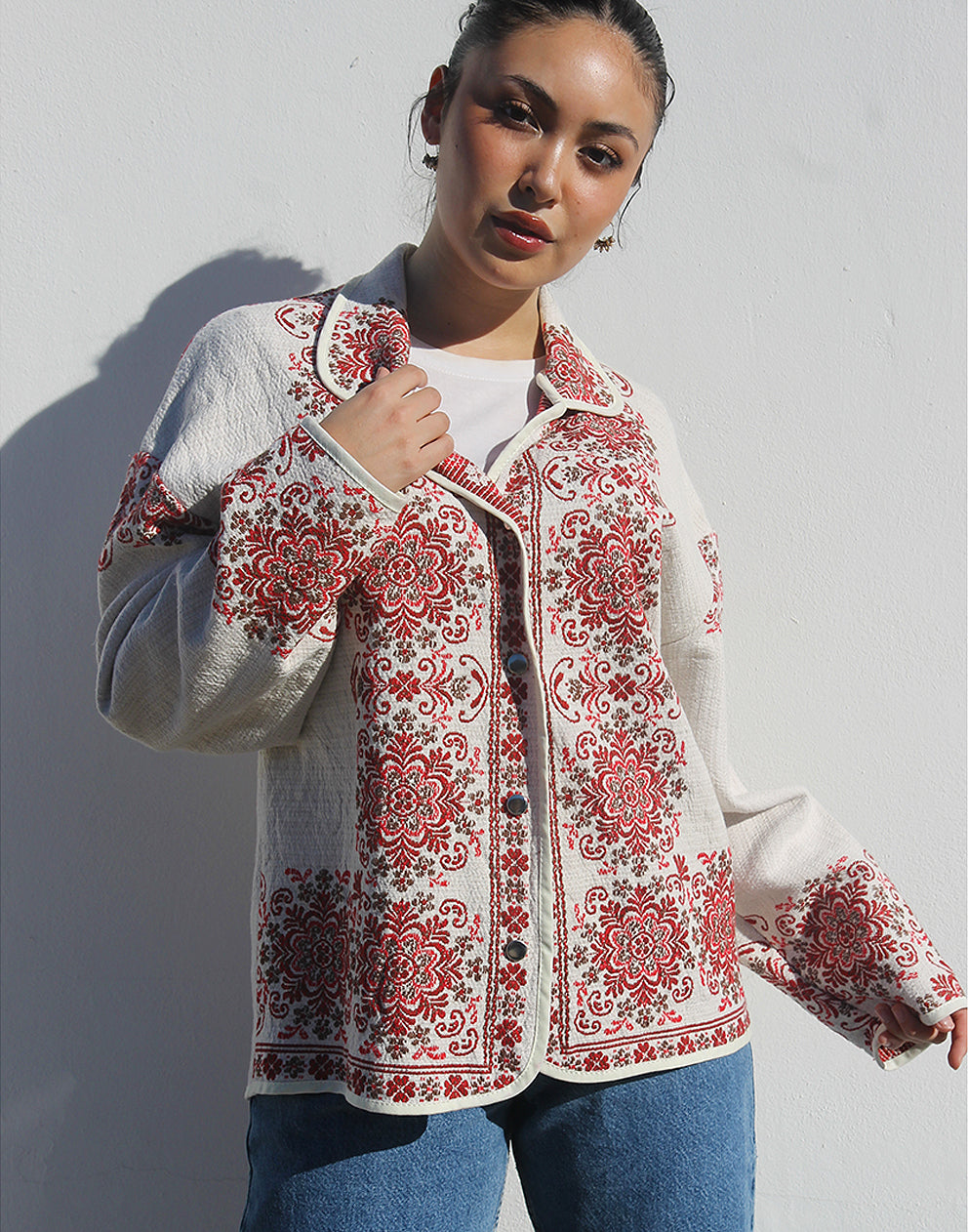 Front view of women’s cream and red floral tapestry coat with classic collar and snap buttons.