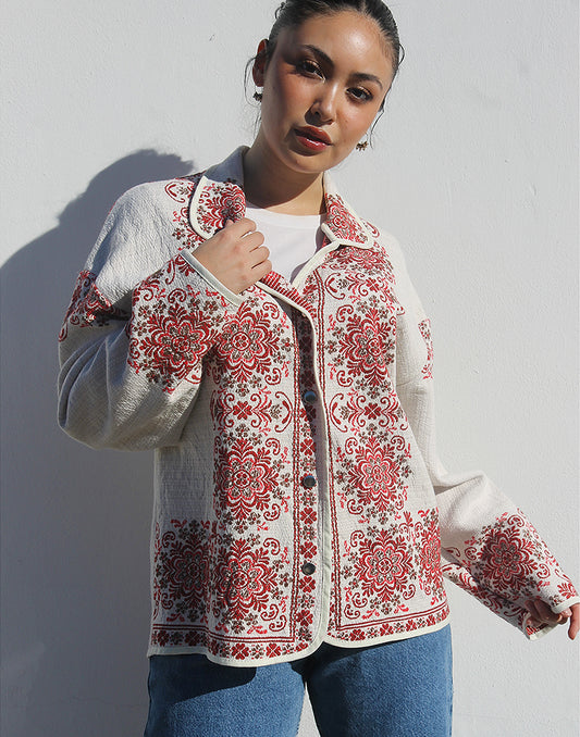 Front view of women’s cream and red floral tapestry coat with classic collar and snap buttons.