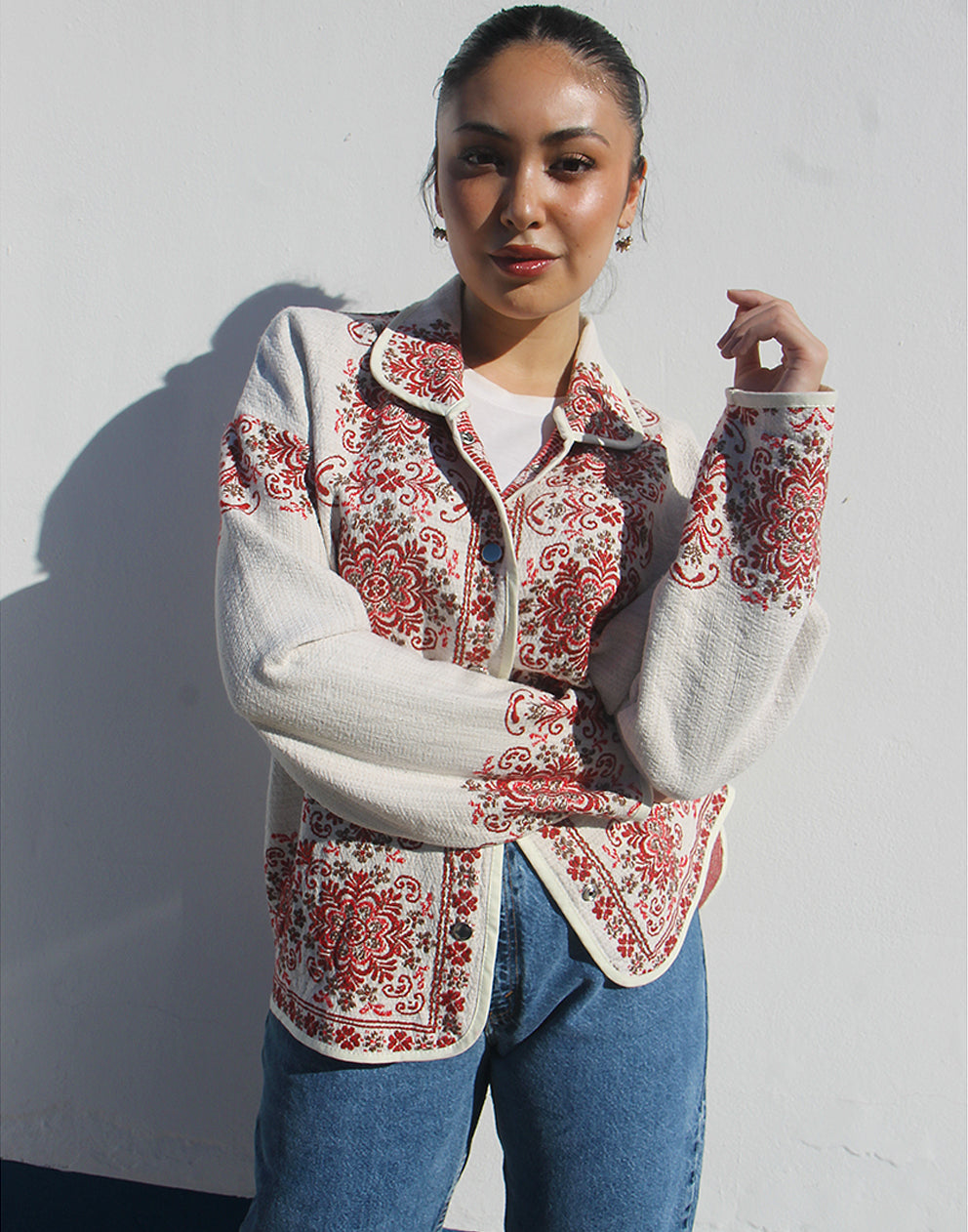 Front view of women’s cream and red floral tapestry coat with classic collar and snap buttons.
