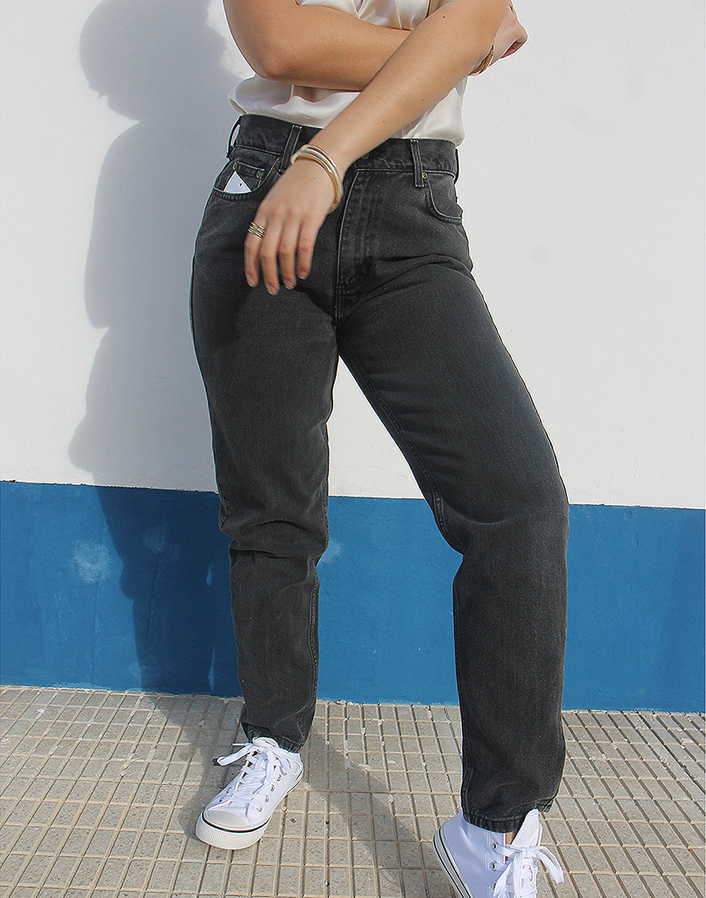Woman wearing vintage Liz Clairborne jeans against a white wall