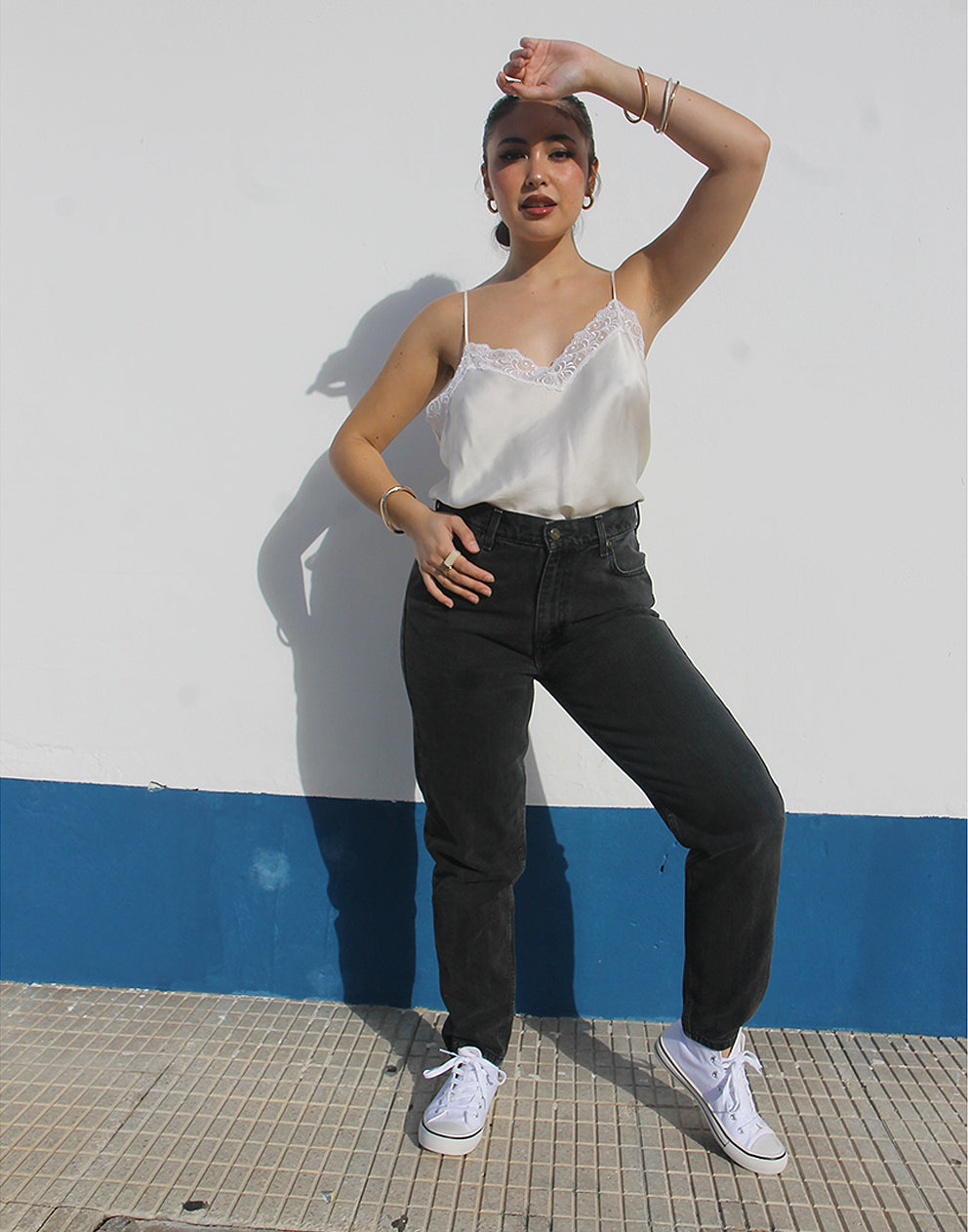 Woman wearing vintage Liz Clairborne jeans against a white wall