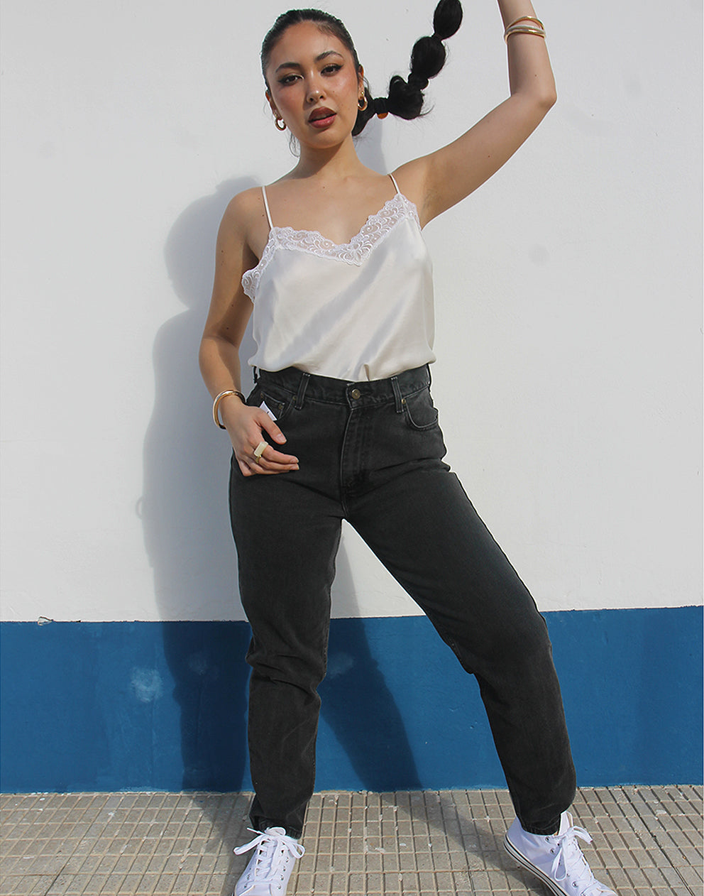 Woman wearing vintage Liz Clairborne jeans against a white wall